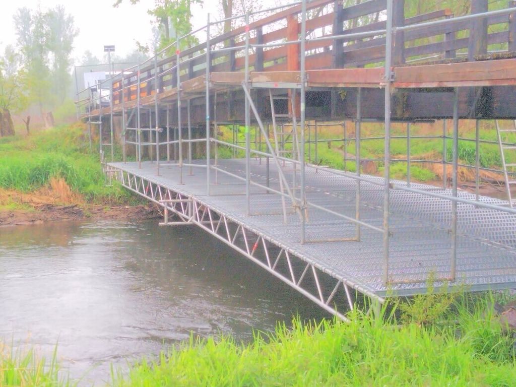 Behelfssteg aus Gerüstbauteilen mit Stahlbelag, im Nebel über einem Fluss